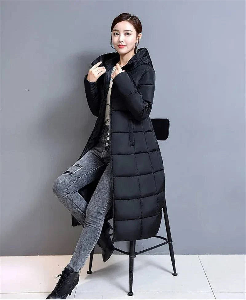 Winter hooded long slim-fit padded jacket for women, black, over-the-knee length, with cozy hood and water-resistant outer layer.