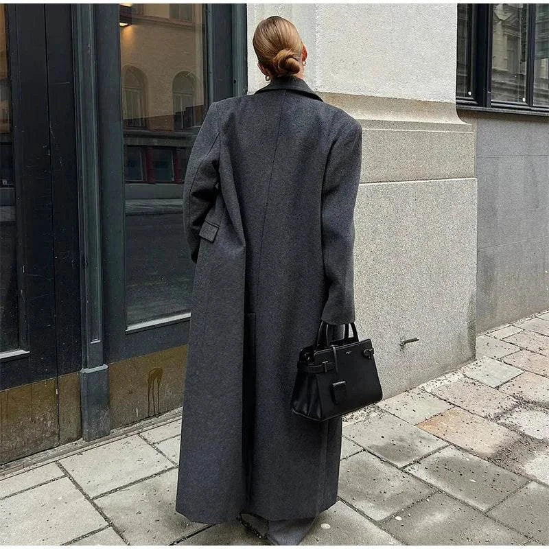 Fashion women overcoat, double-breasted autumn winter jacket with turn-down collar and full sleeves on a city street.