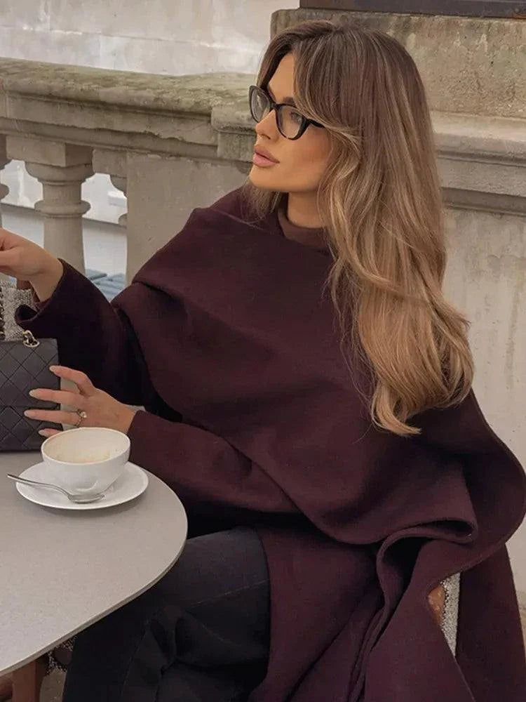 Woman wearing Fashion Ancora Red Scarf Collar Cape Coat in an outdoor cafe setting.