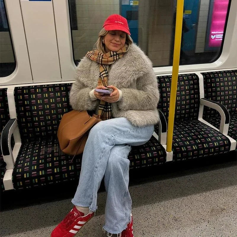 Fashion gradient fluffy faux fur jacket with oversized collar on woman sitting in a subway.