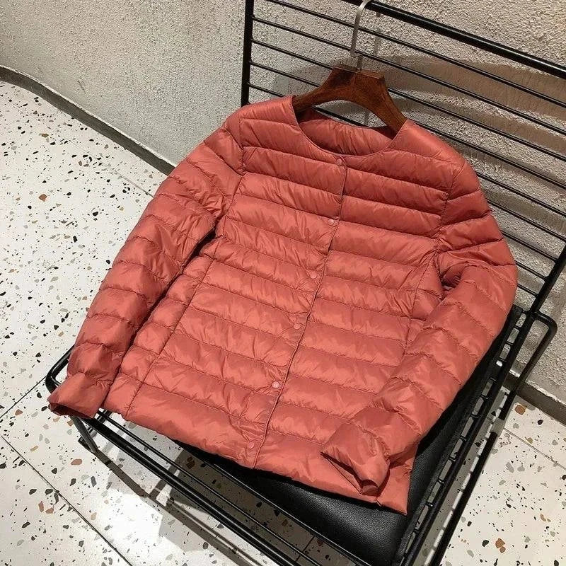 Ultralight warm women’s puffer jacket by Alfadarling in coral pink with O-neck design.