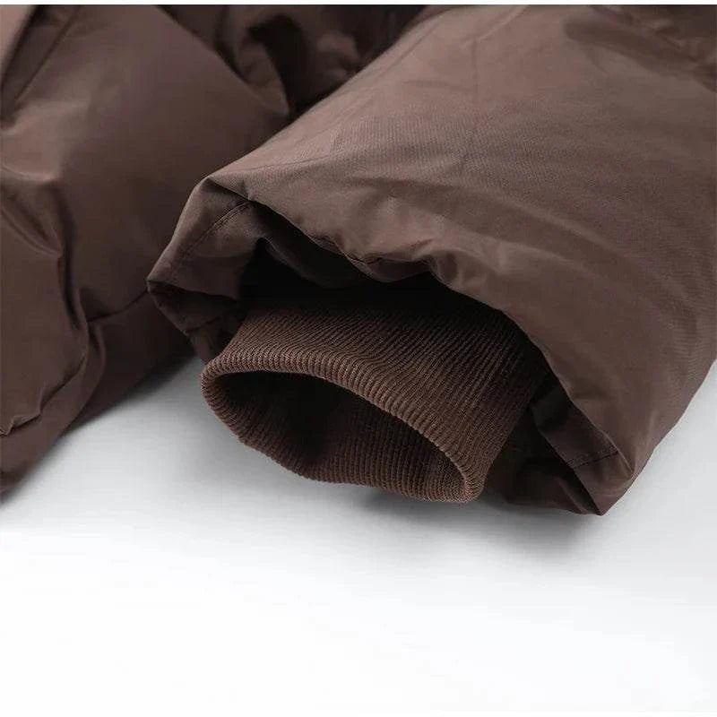 Close-up of vintage brown hooded cotton padded coat sleeve, showcasing quality fabric and tailored fit.