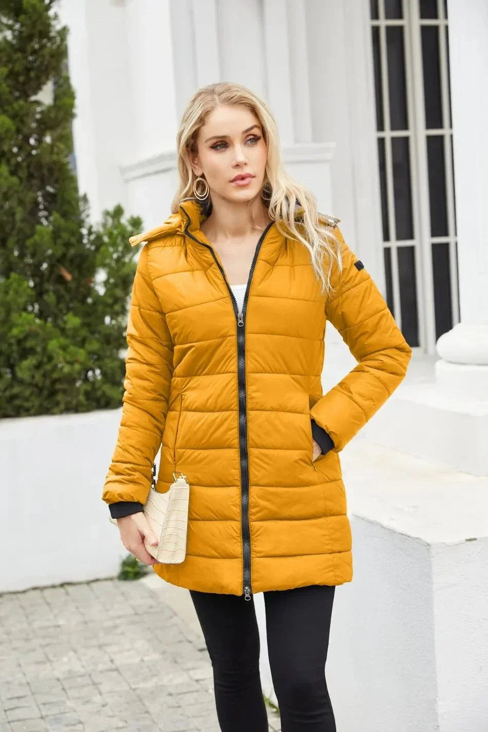 Women's mustard yellow waterproof parka with detachable hat, zipper closure, long sleeves, and loose fit for autumn and winter.