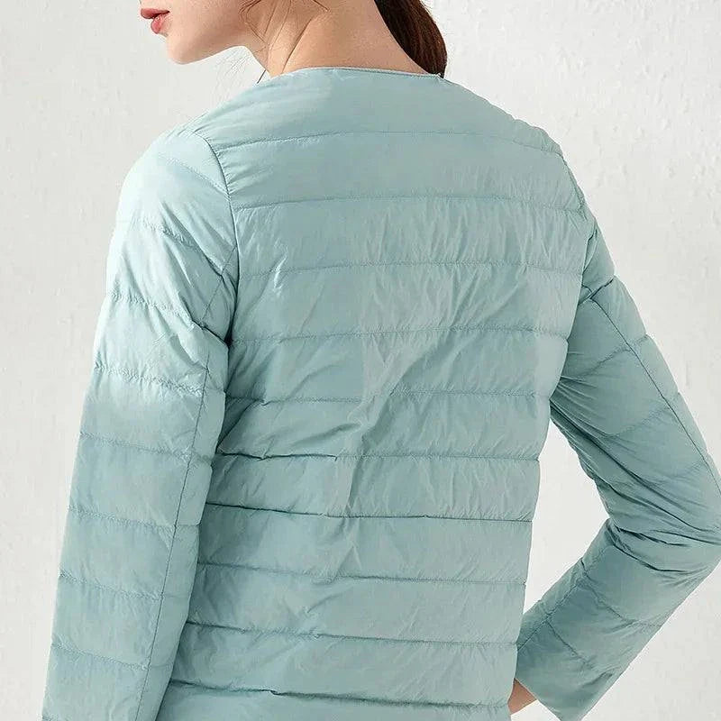 Ultralight warm women's puffer jacket by Alfadarling with collarless O-neck design, ideal for layering, in light blue.