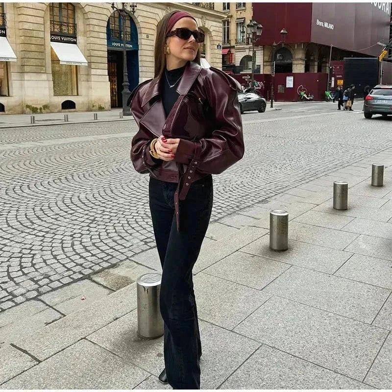 Vintage cropped leather jacket with braid lapel, modeled outdoors in urban setting.