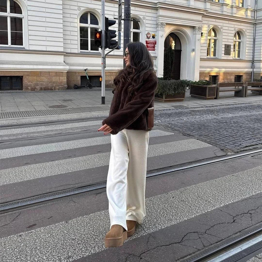 Winter women's fleece jacket with lapel collar, worn by a person standing on a city street.