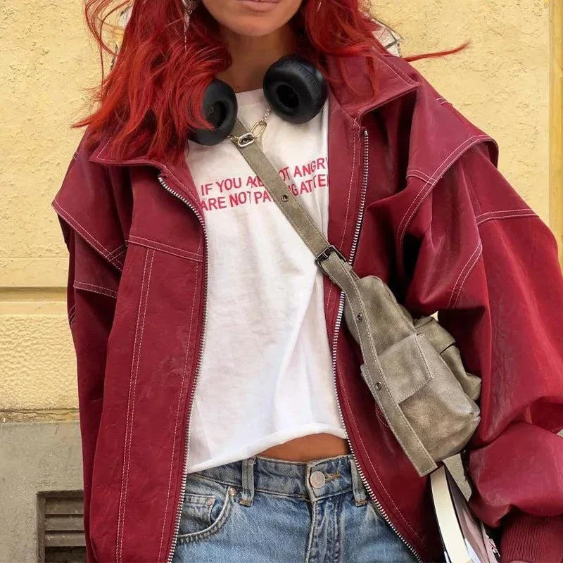 Vintage lapel leather jacket for women in red with long sleeves and lace-up details, styled with casual jeans and a white top.