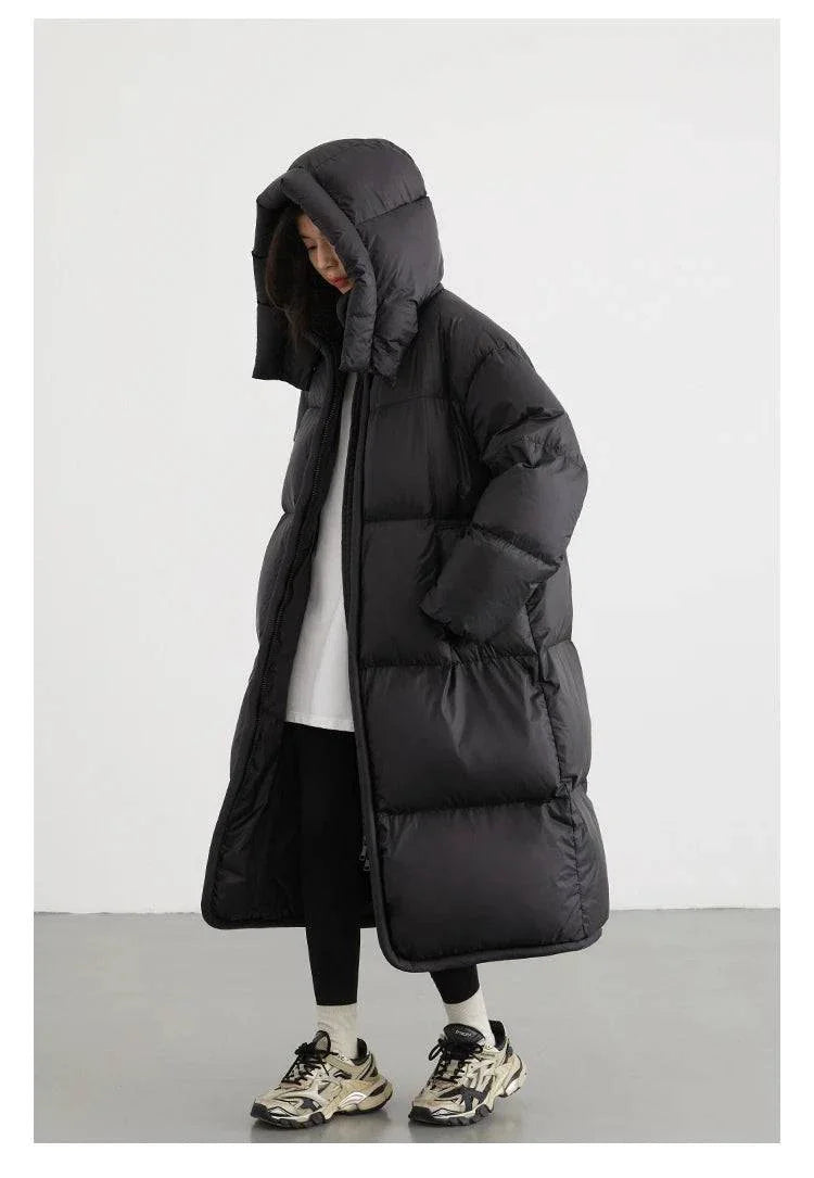 Long black women's down coat with detachable hood, designed for warmth and style in autumn and winter 2023.