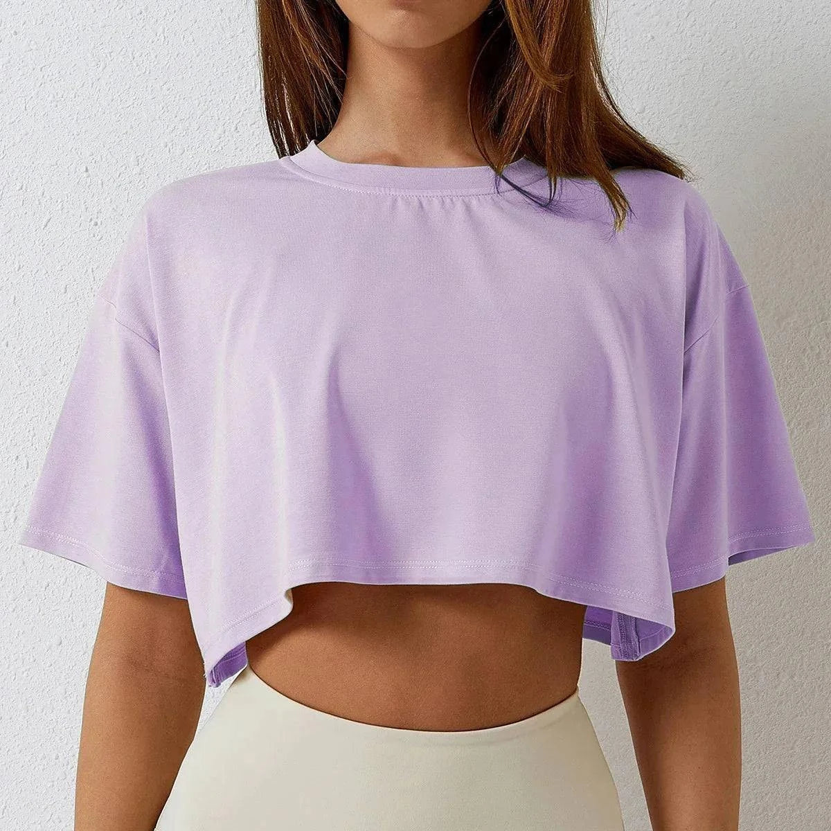 Cotton crop top for active women in lavender color, short sleeves, trendy navel-baring design for yoga and workouts.