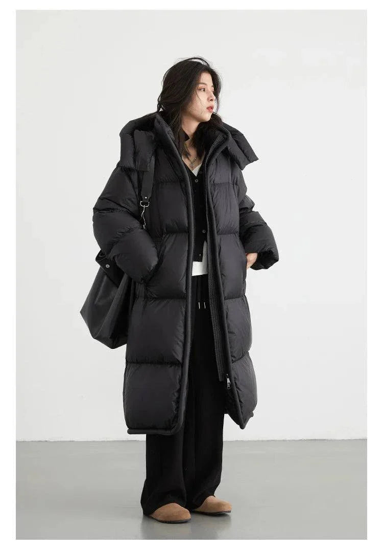 Women's long black down coat with detachable hood, thick and soft for autumn and winter warmth, styled for elegance and comfort.