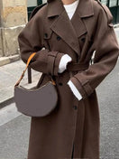 Switch Elegant brown woolen overcoat with loose lapel and adjustable belt. 1 image