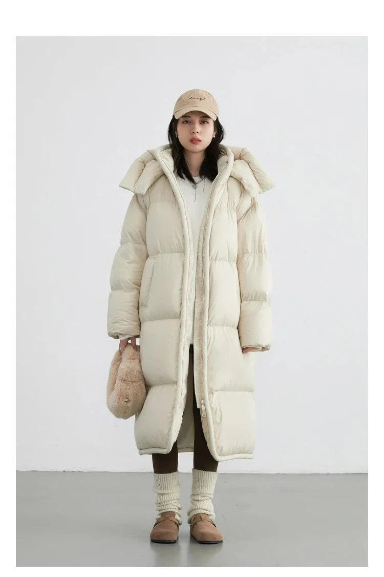 Women's long down coat with detachable hood, thick soft padding, and zipper closure for autumn/winter 2023.