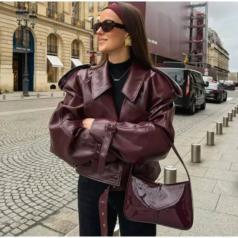 Vintage cropped leather jacket with braid lapel and long sleeves in maroon; chic retro street style.